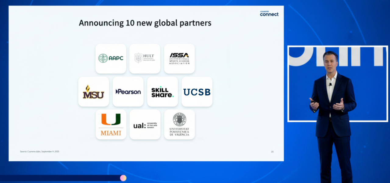 man talking in front of blue background with global partner logos