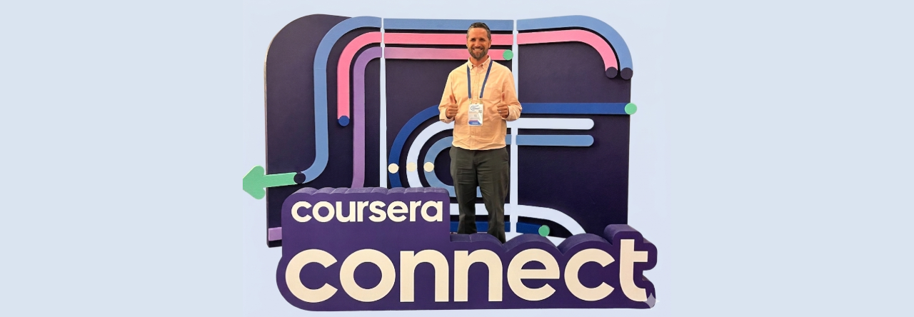 man standing with blue background and coursera connect sign