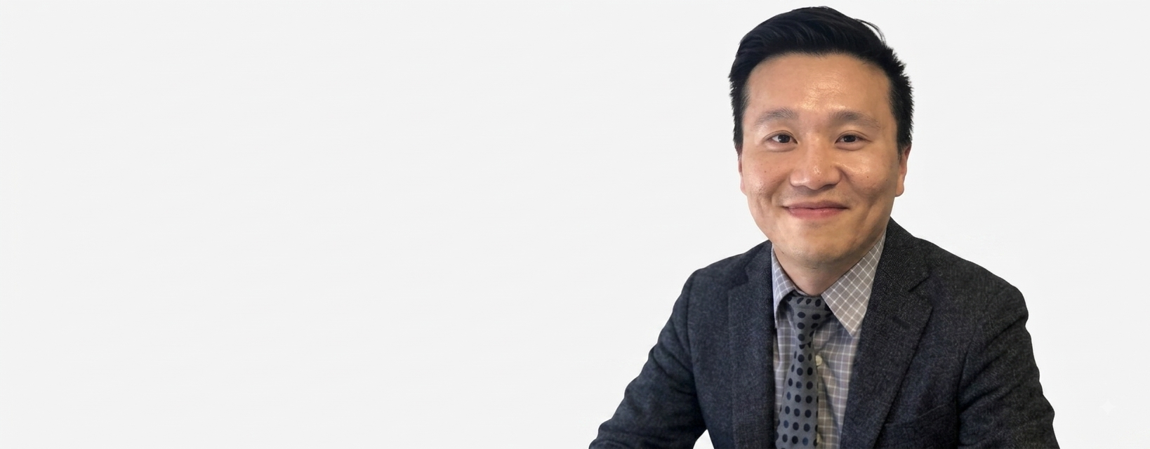 man sitting with suit and light grey background